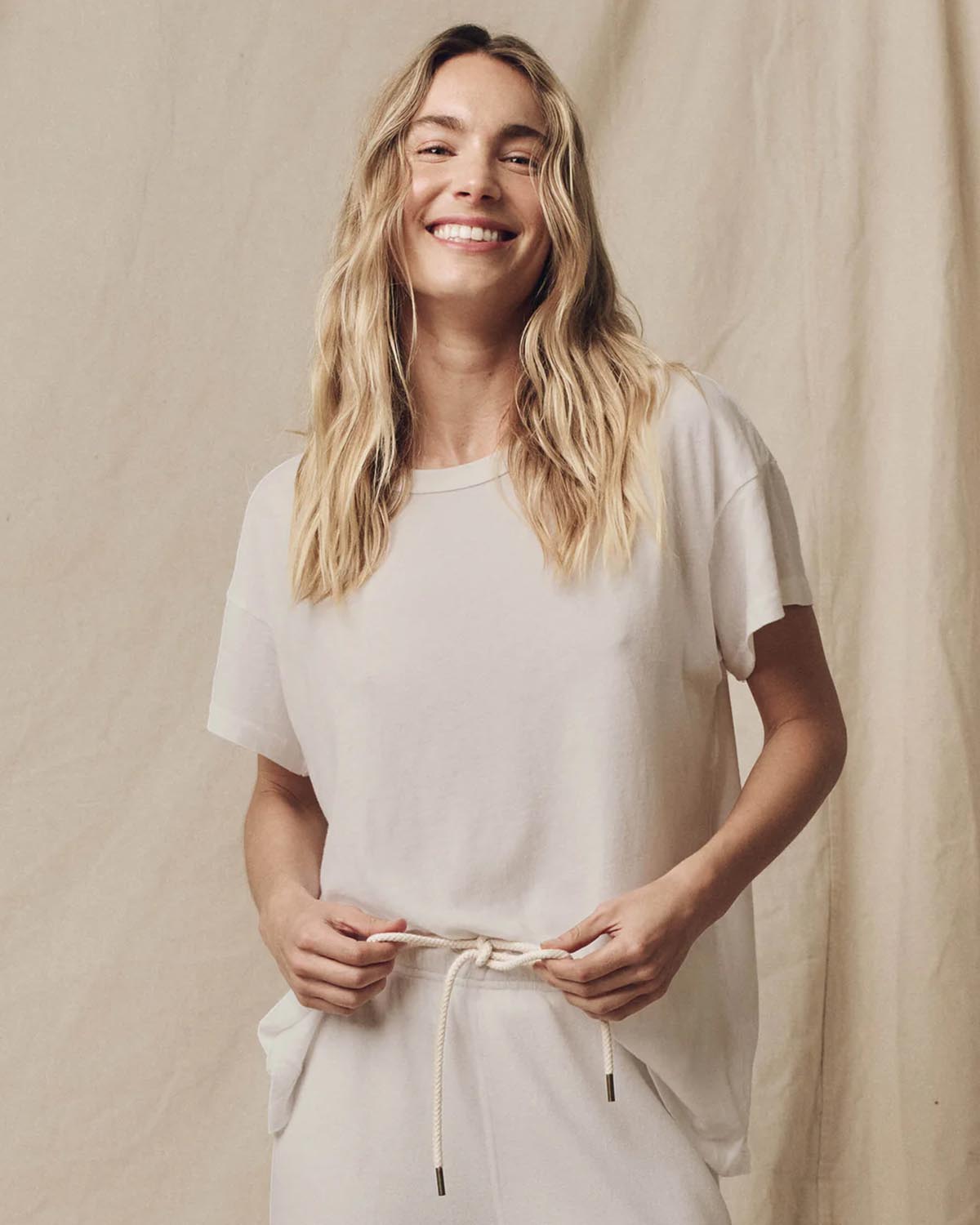 Produit Tee-shirt en coton écru The Boxy Crew de The Great, porté avec un bas de jogging décontracté pour un look effortless.
