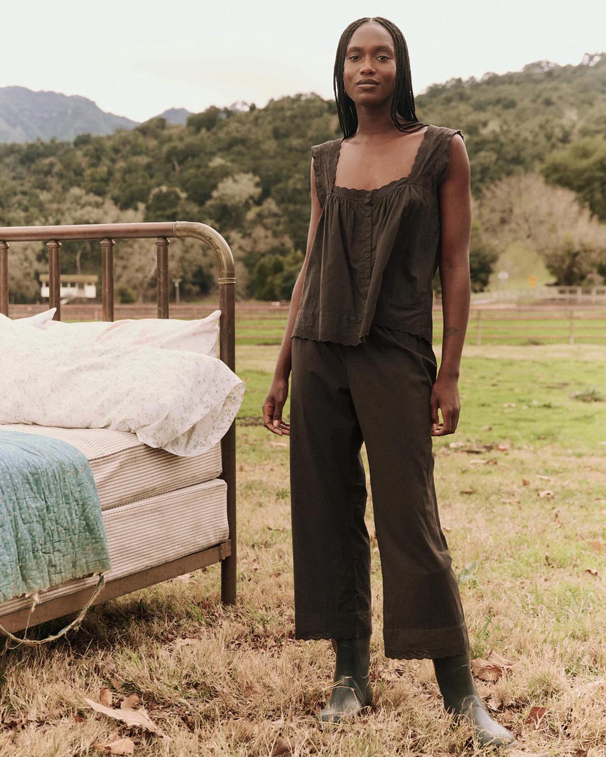 Pantalon taille élastique en coton brodé en bas noir The Eyelet The Great. Thème Sleep. Porté avec un top assorti et des bottes.