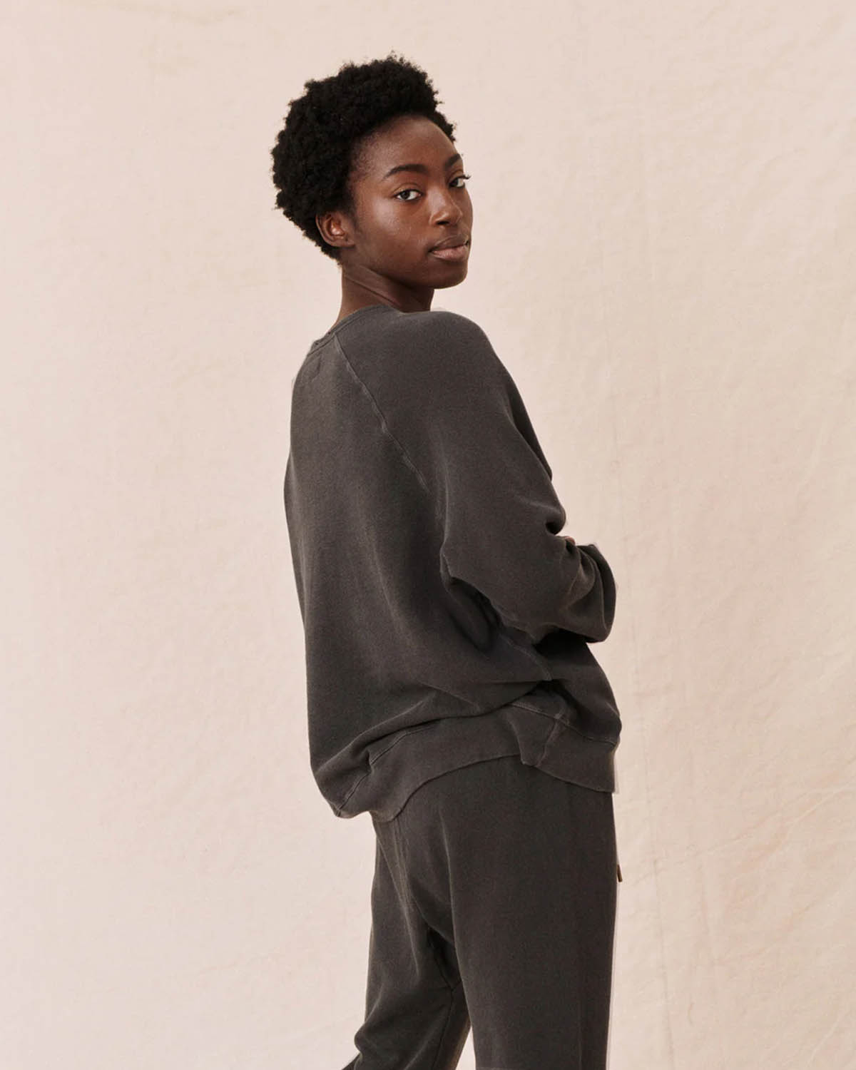 Sweatshirt Slouch The Great en coton noir délavé. Porté avec un jogging noir délavé. Vue dos.