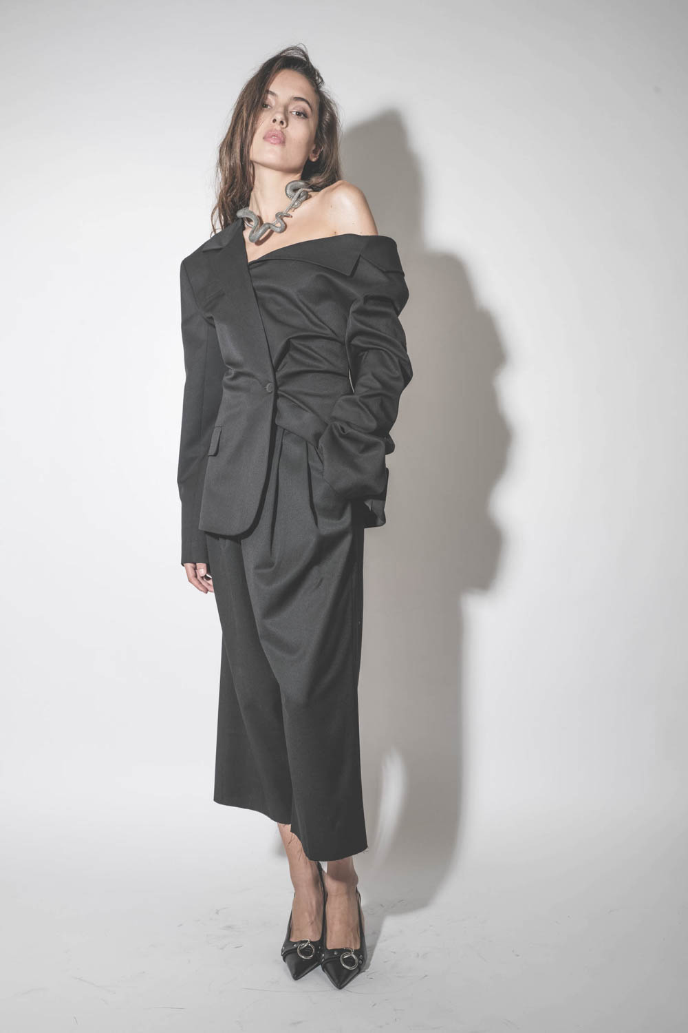 Produit Blazer asymétrique en laine froide noire Anissa Vautrait. Porté avec un pantalon large et court assorti. 