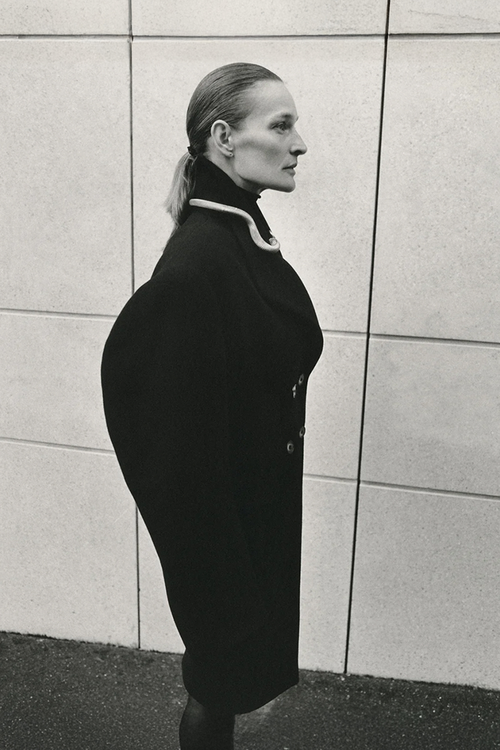 Manteau manches longues Amanda Vautrait en laine noire. Vue porté de profil. 
