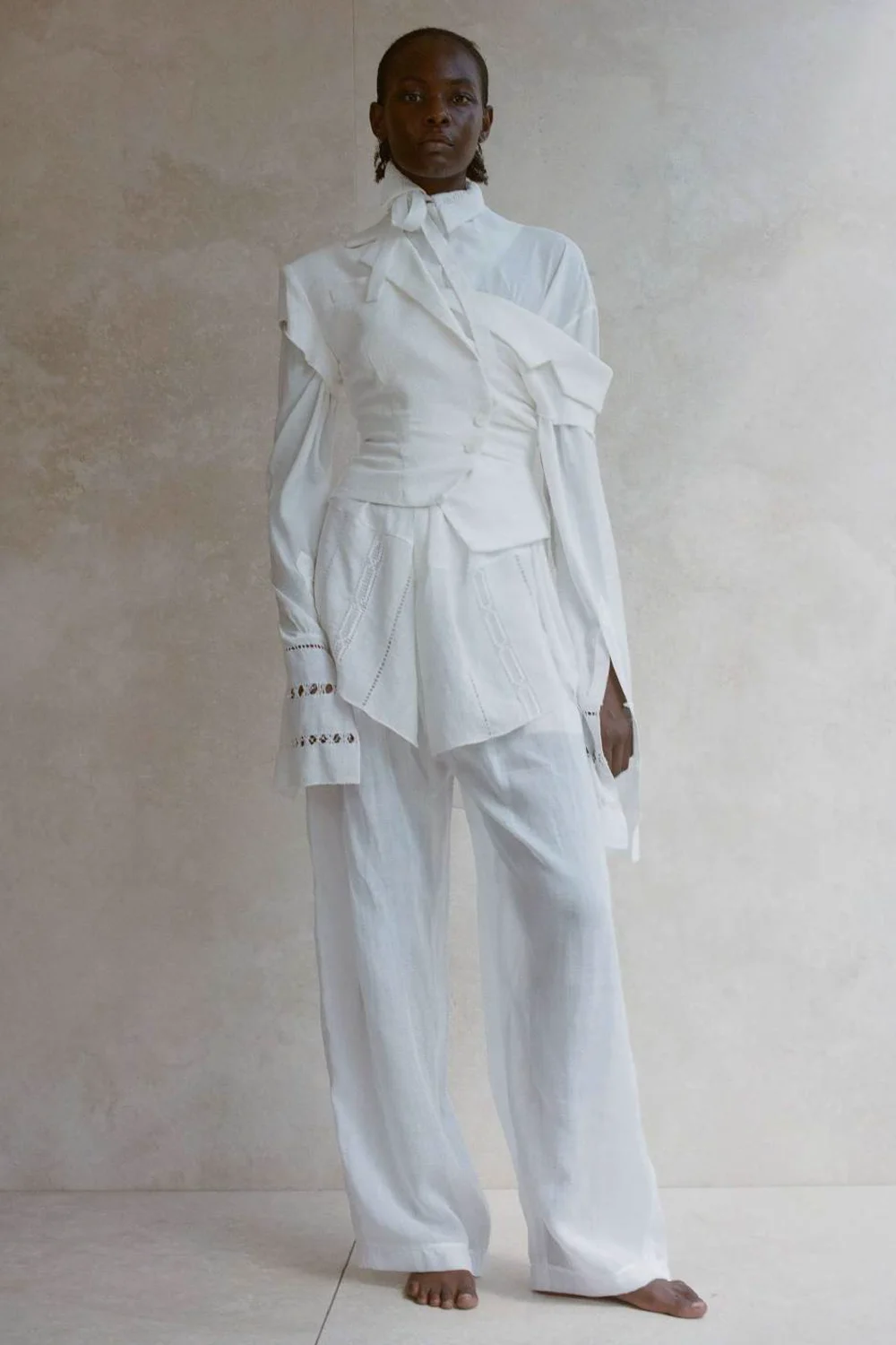 Produit Pantalon large en lin blanc Amélia Vautrait. Porté avec une blouse en dentelle et une veste cintrée. Face. 