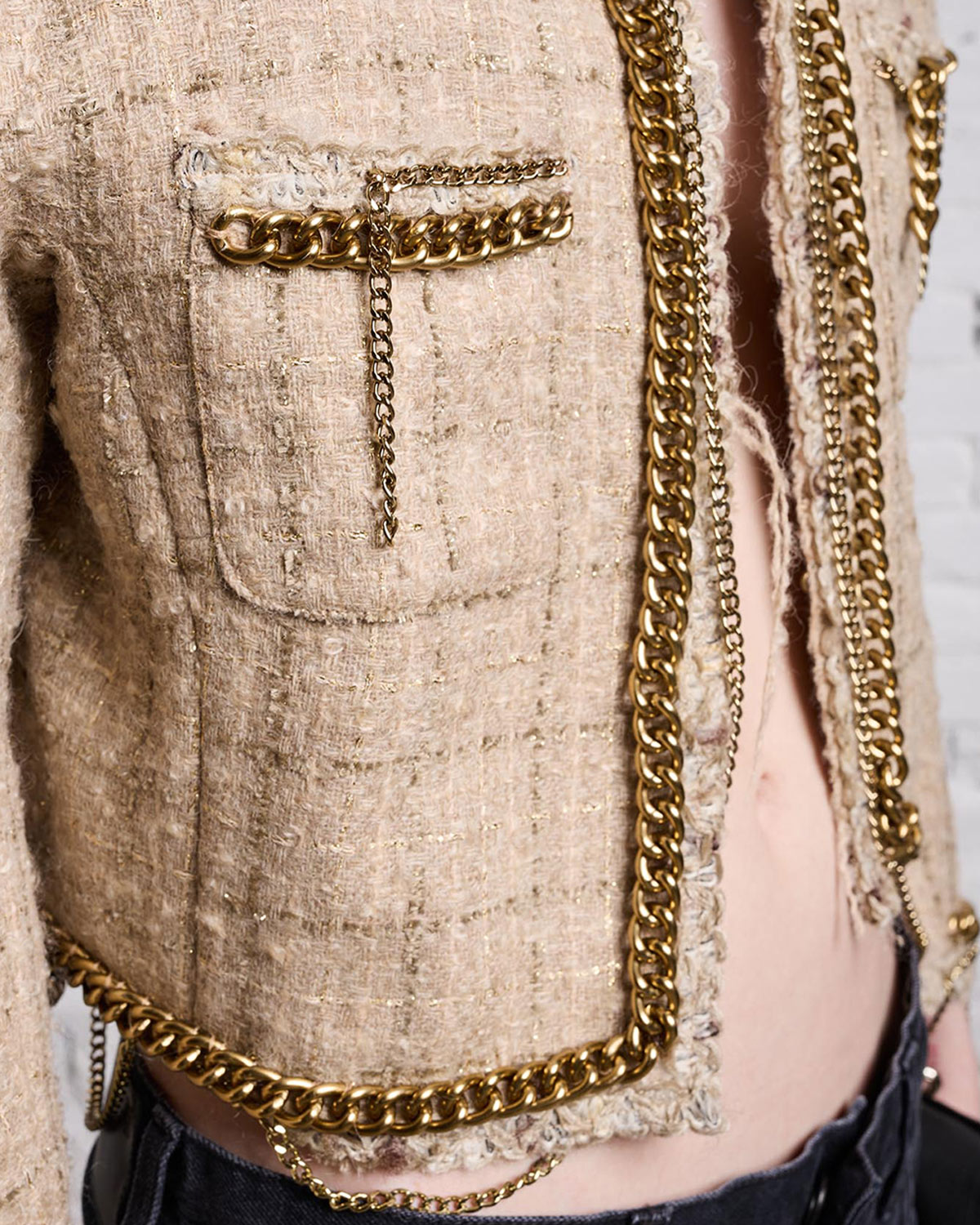 Veste courte en tweed beige avec détails de chaines R13. Détails de matière et chaines dorées.