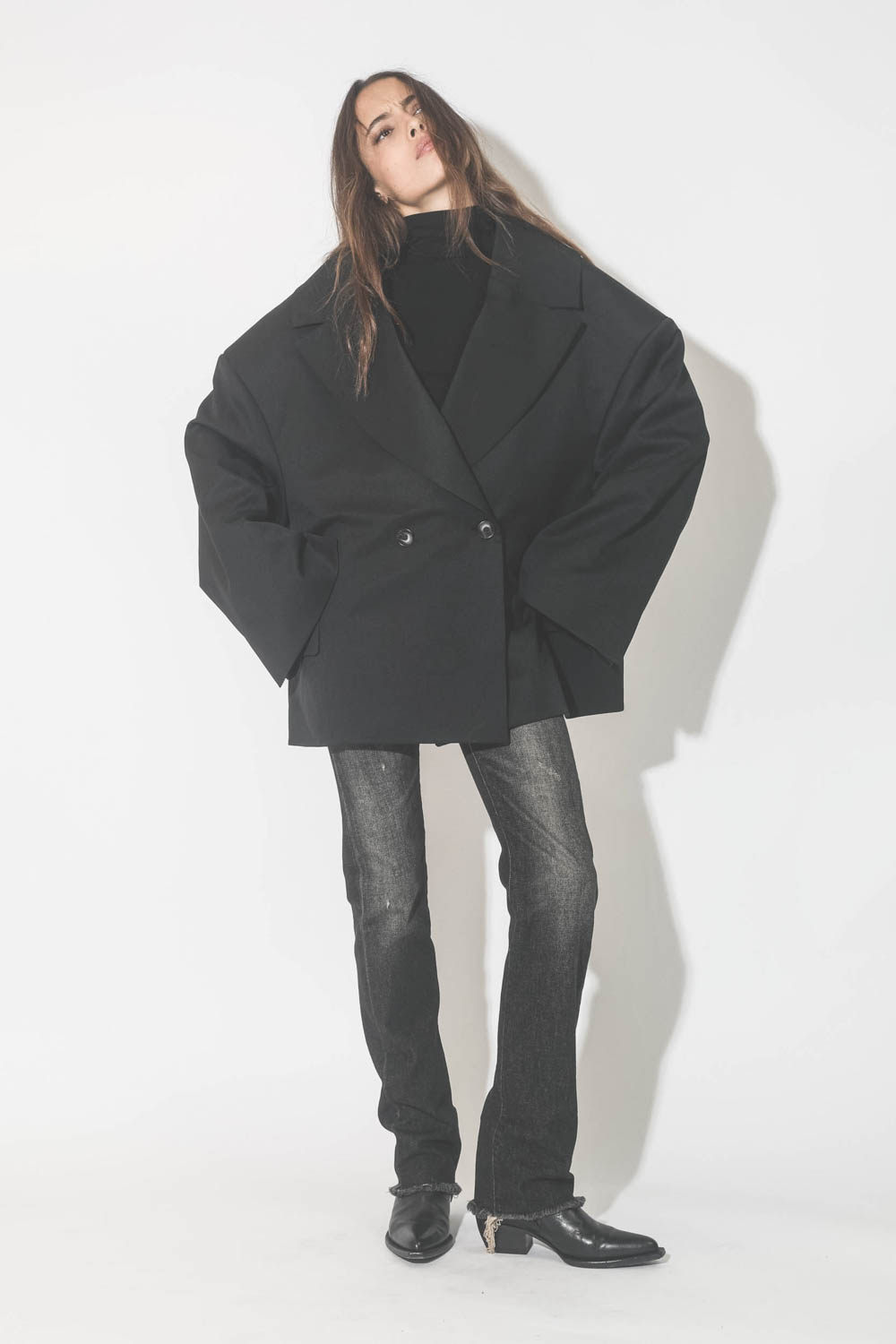 Veste oversize noire Kristeva Vautrait. Porté avec un jeans noir et des santiags.