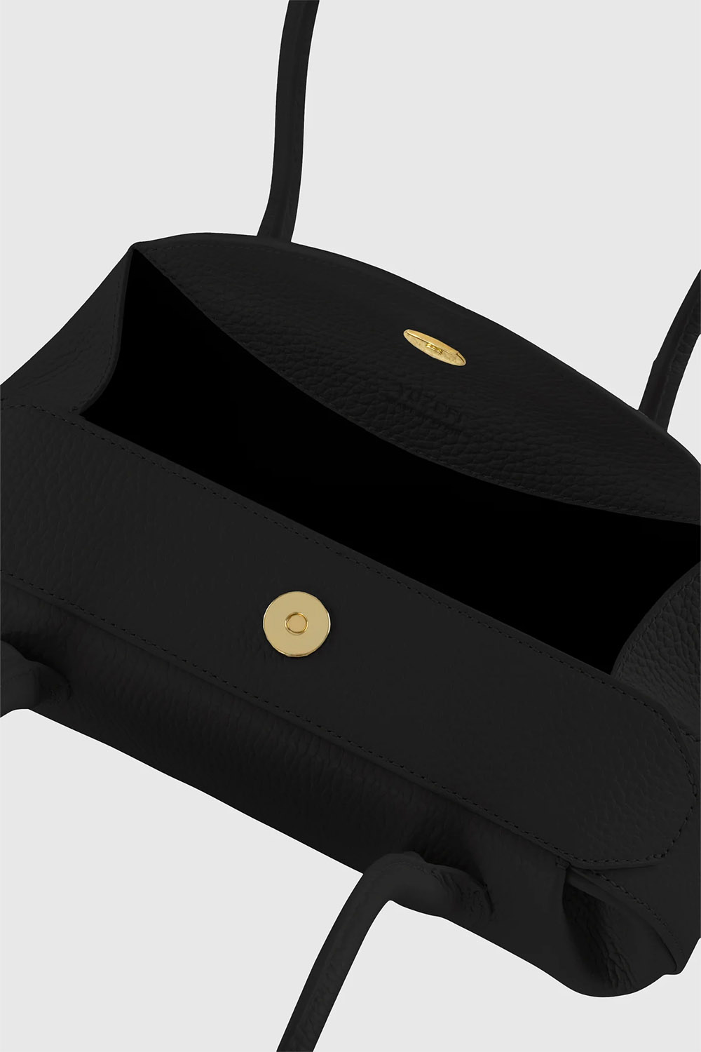 Sac Mini Oyster Yuzefi en cuir grainé noir, mini sac baguette porté épaule au design contemporain. Détail de la fermeture à rabat aimantée sur le dessus du sac.